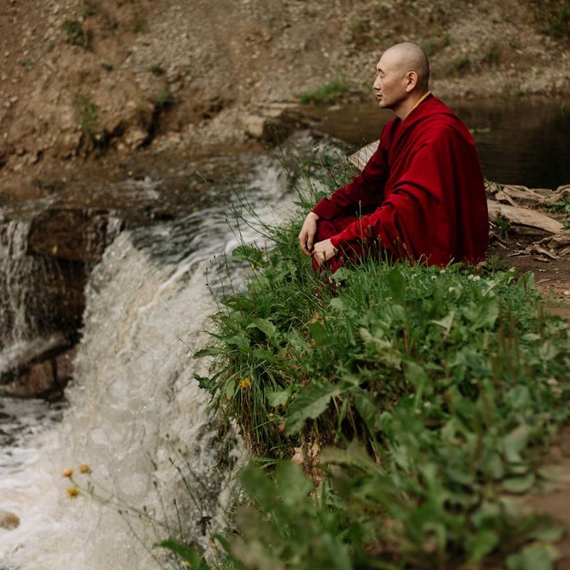 A person sitting in a calm, focused posture outdoors.