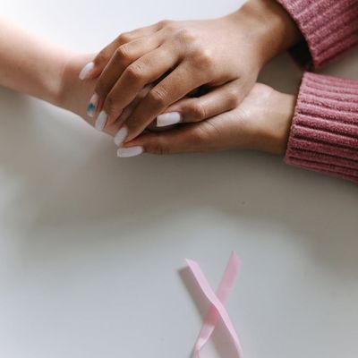 Close-up of hands in a meditative gesture against a textured background.